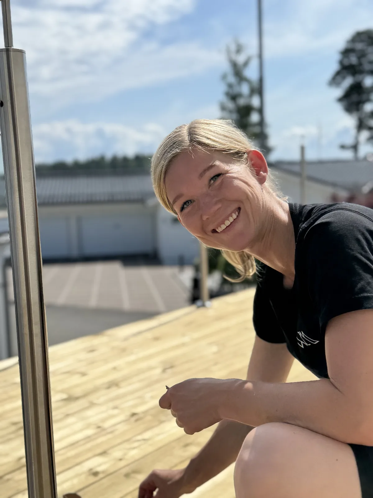 En person vid ett glasräcke på en träterrass